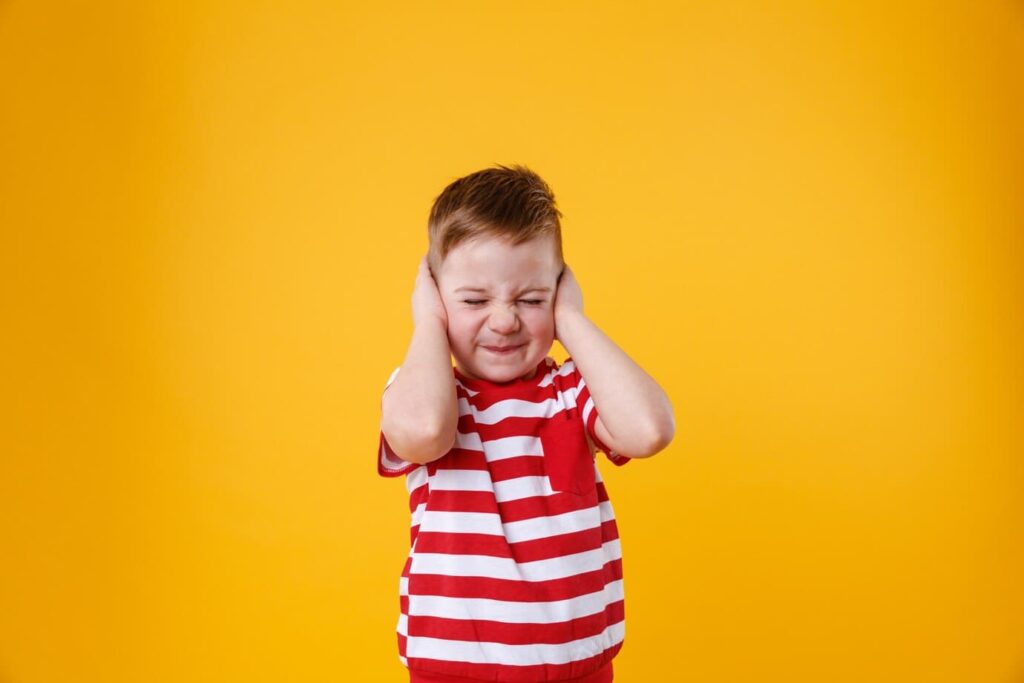 baby covering ears with hands