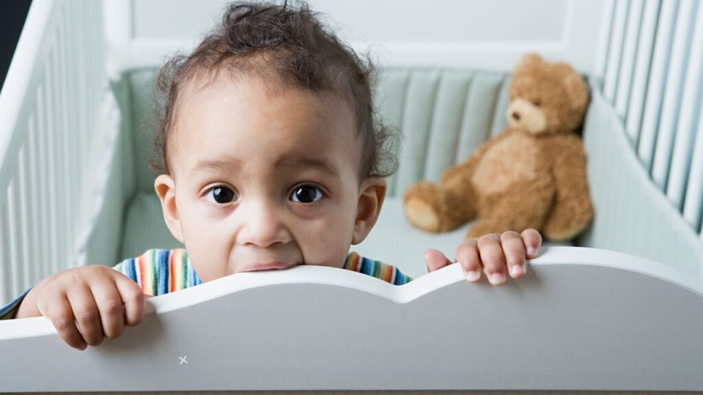 Baby Chewing on Crib